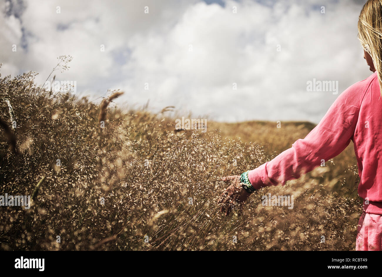 Girl walking on meadow Stock Photo - Alamy