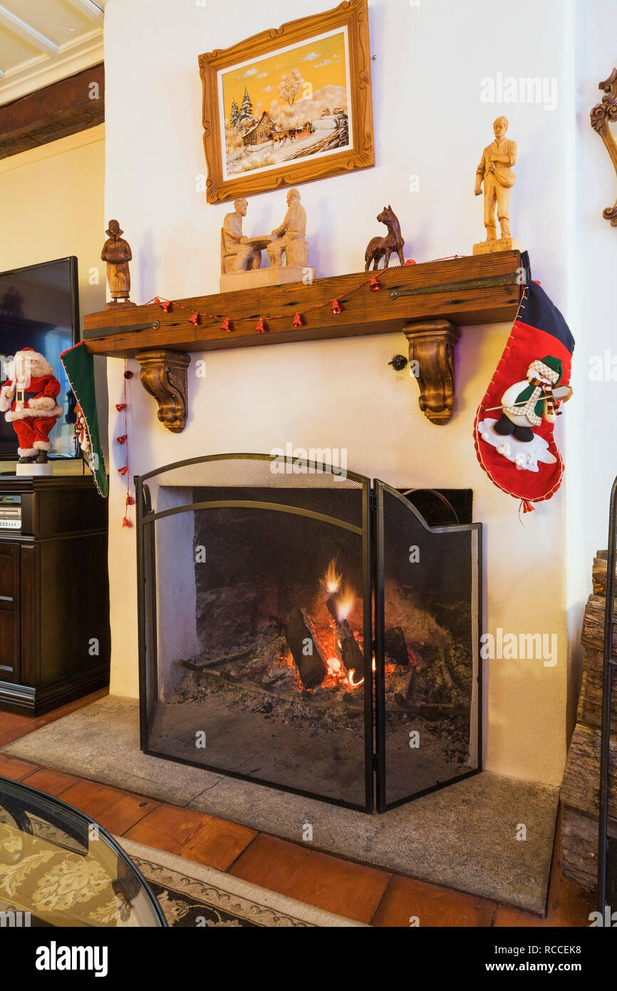 Lit Wood Burning Fireplace Decorated With Christmas Stockings
