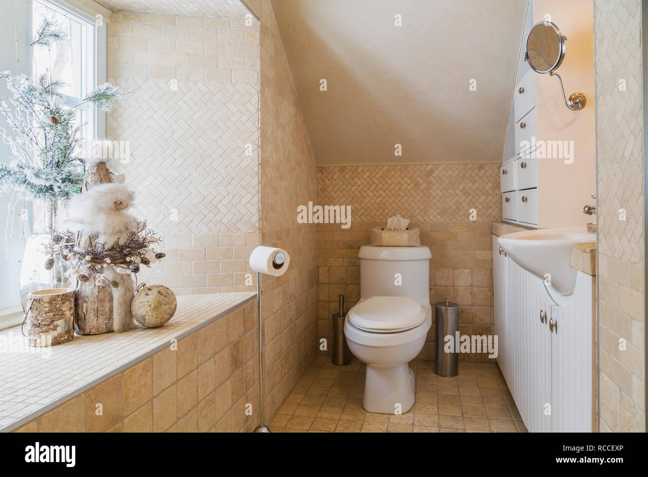 Main bathroom with travertine tile floor on the upstairs floor inside an old renovated circa 1840 Canadiana cottage style home Stock Photo