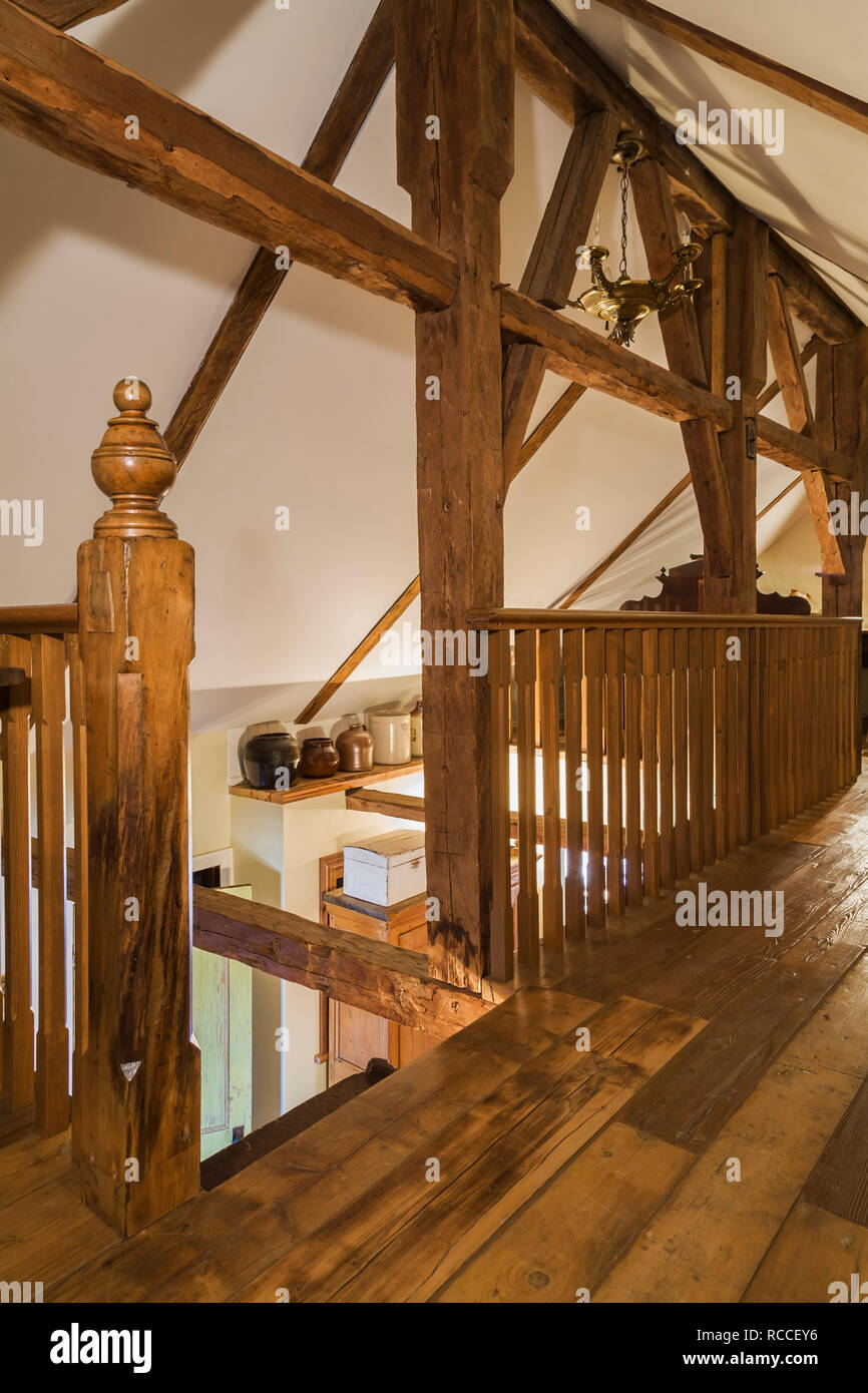 Attic room with timber framing, wooden railing and pinewood floorboards