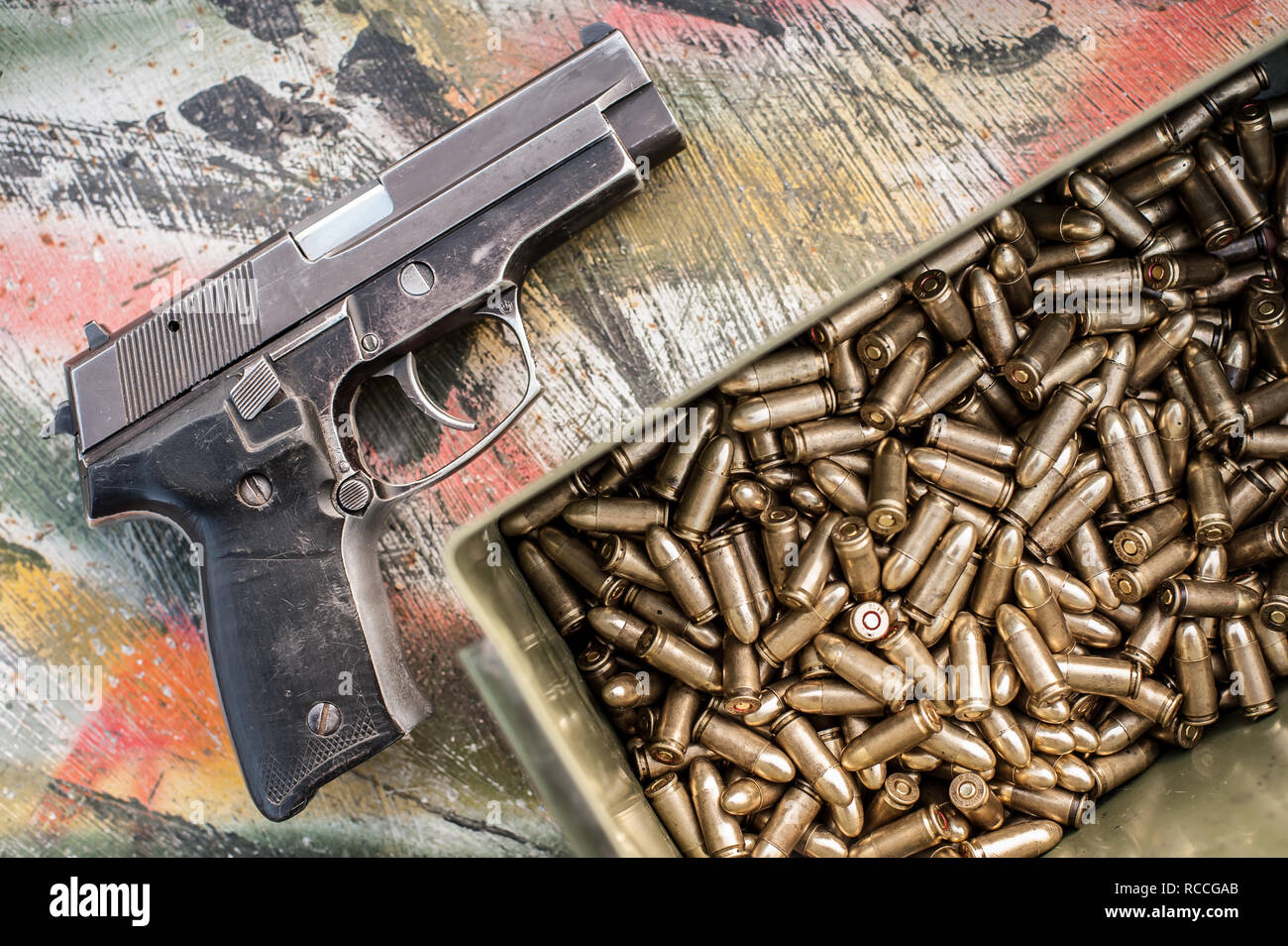 Top view of gun and ammunition box on the table. Bullets for pistol in