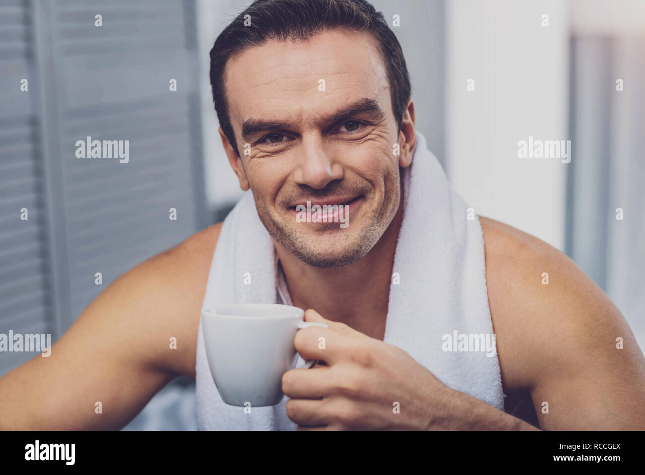Delighted joyful man having coffee Stock Photo