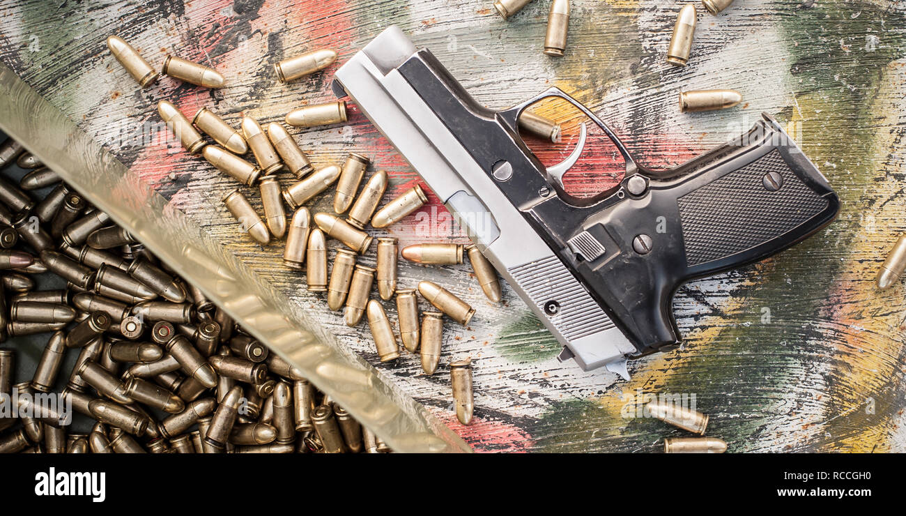 Top view of gun and ammunition box on the table. Bullets for pistol in