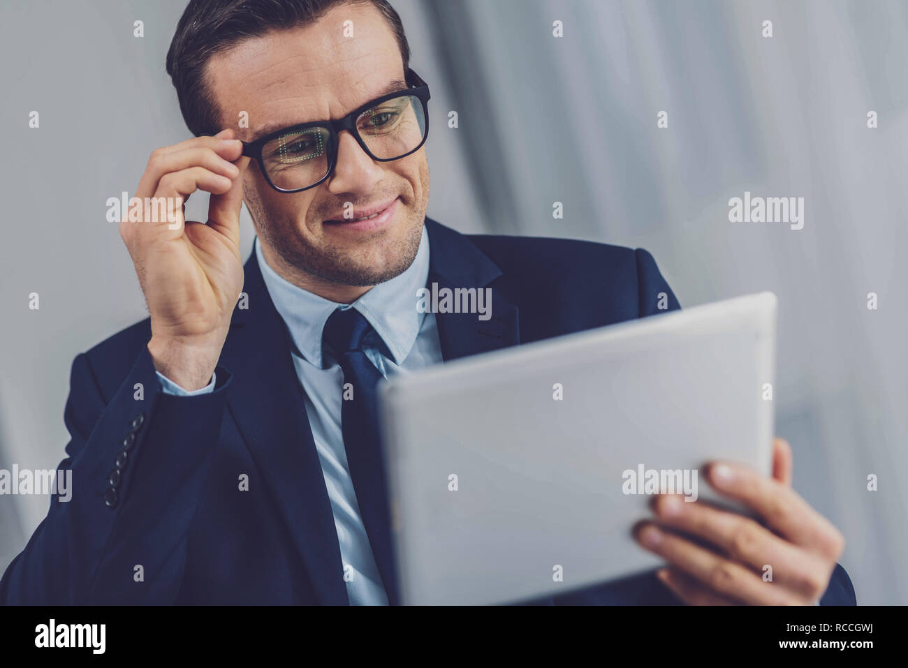 Cheerful positive man looking at the tablet screen Stock Photo