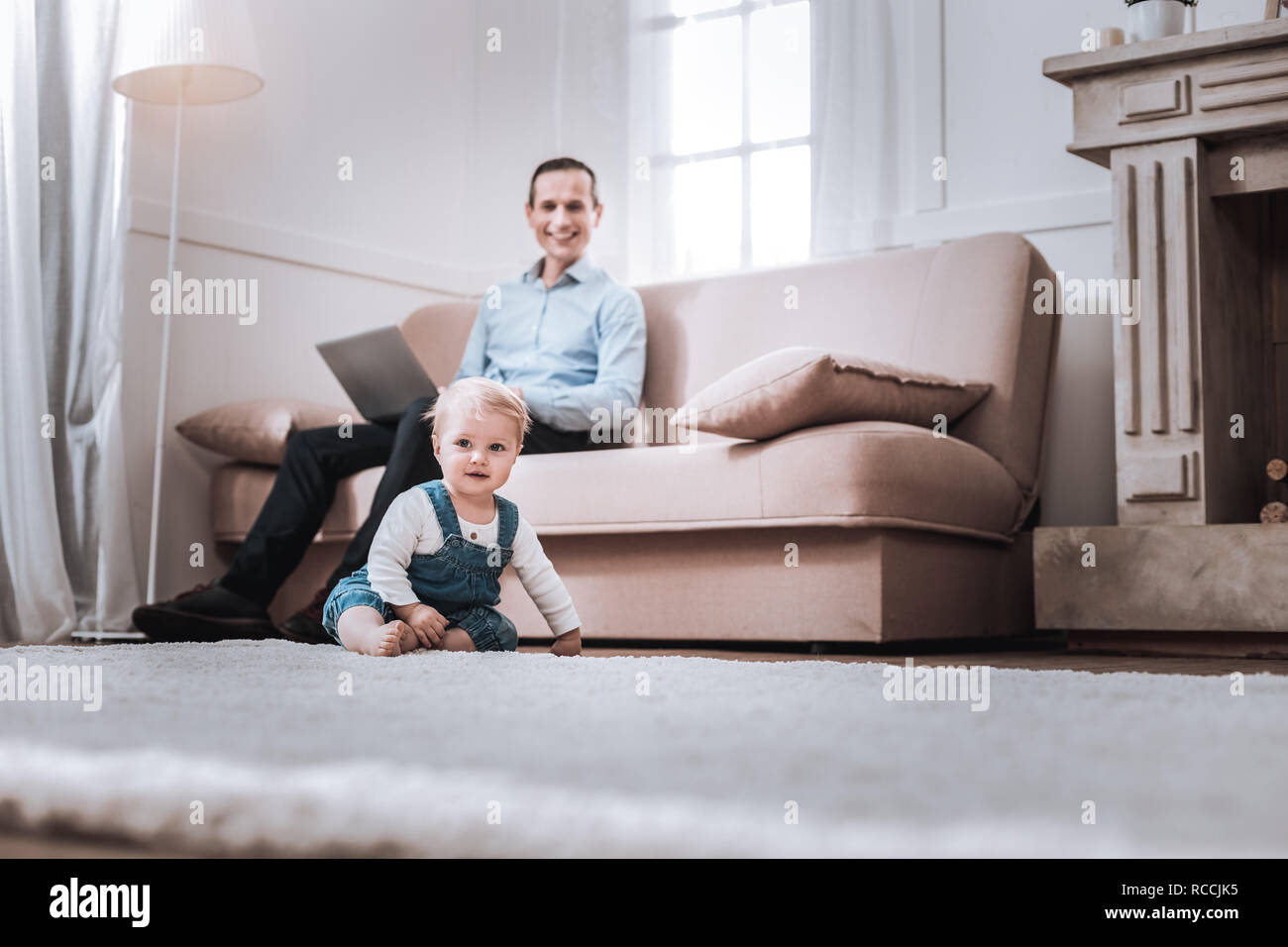 Happy cute boy sitting on the floor Stock Photo - Alamy