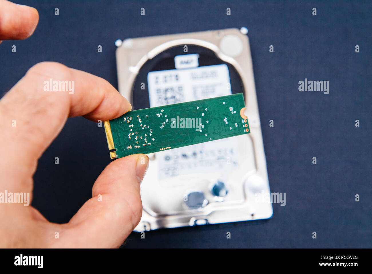 Man holding NVME PCIE fast ssd flash memory disk drive with old HDD platter  hard disk drive in the background - computer upgrade Stock Photo - Alamy