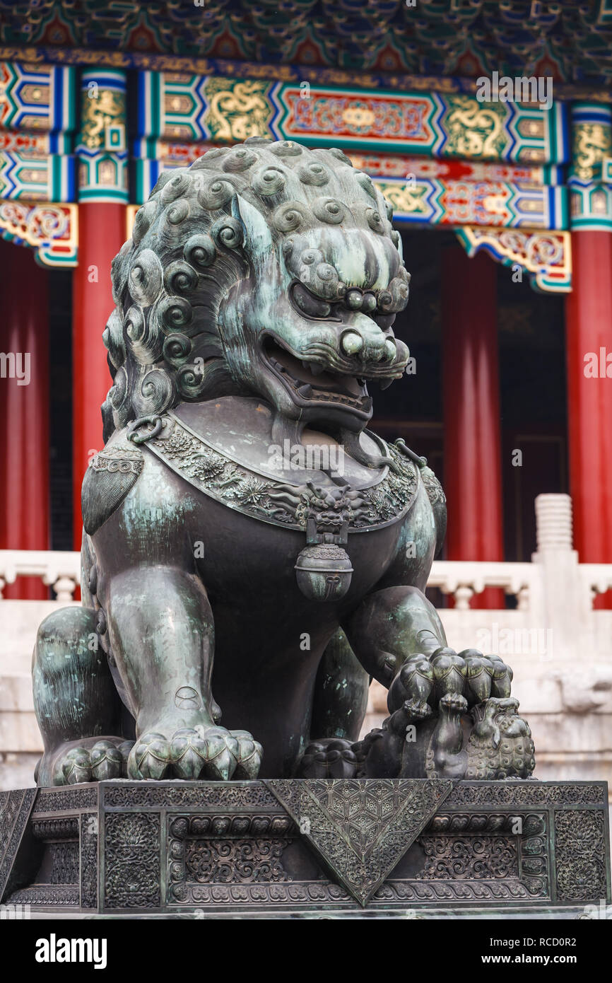 Stone, Chinese lion statue in front of red columns of the forbidden city in Beijing China Stock Photo