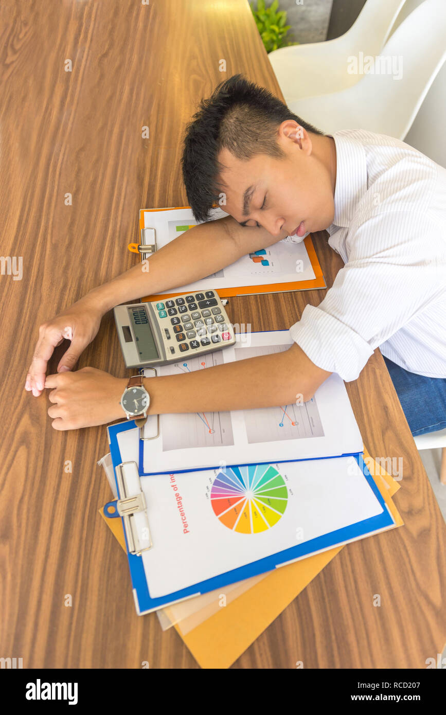 Young Man Fall Asleep On Working Desk With Financial Documents