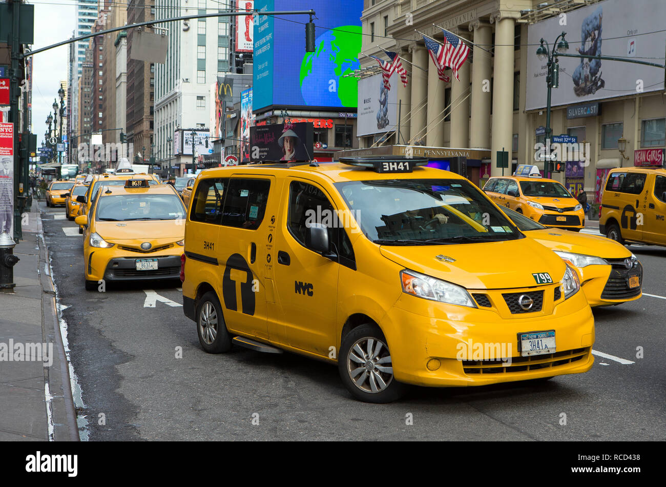 A row of Yellow Taxi cabs outside Pennsylvania Station and opposite the Hotel Pennsylvania on 7th Avenue in New York City, NY, USA. Stock Photo