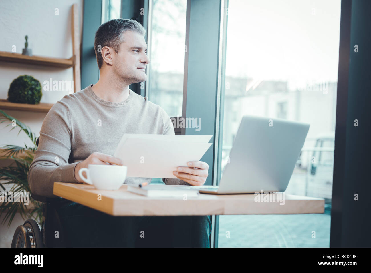 Thoughtful man looking through the window Stock Photo