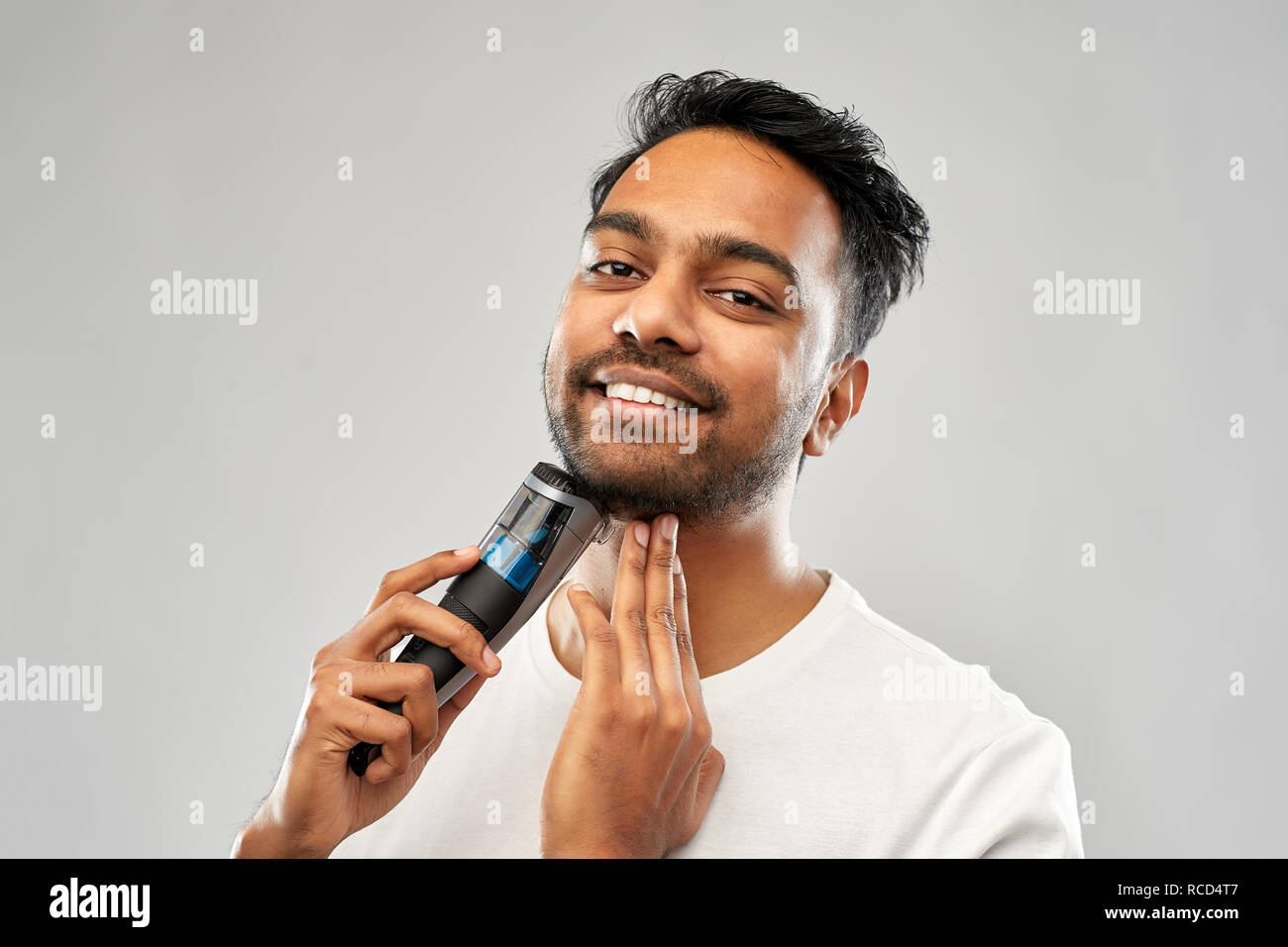smiling indian man shaving beard with trimmer Stock Photo - Alamy