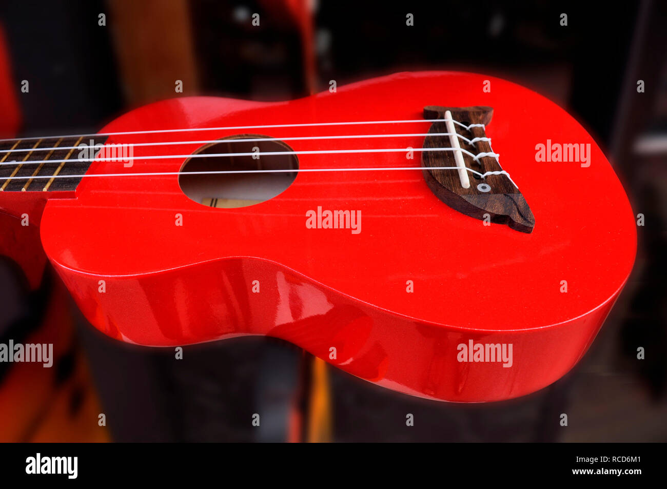 A bright red guitar on display in the window of a music store, Kauaii