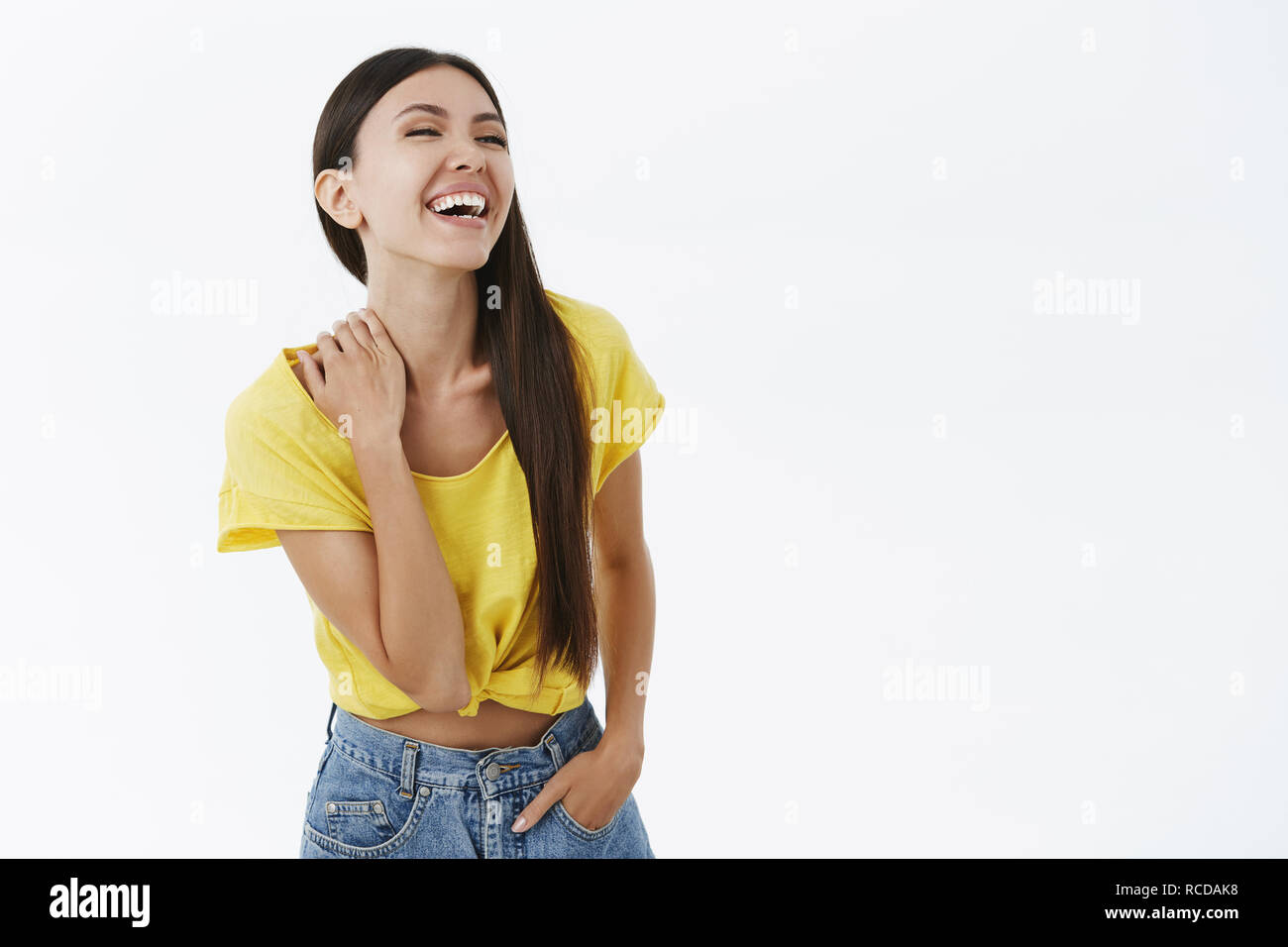Carefree enthusiastic asian woma having fun laughing out loud over funny joke having amusing time looking right touching neck chuckling being entertained in awesome company posing in stylish outfit Stock Photo