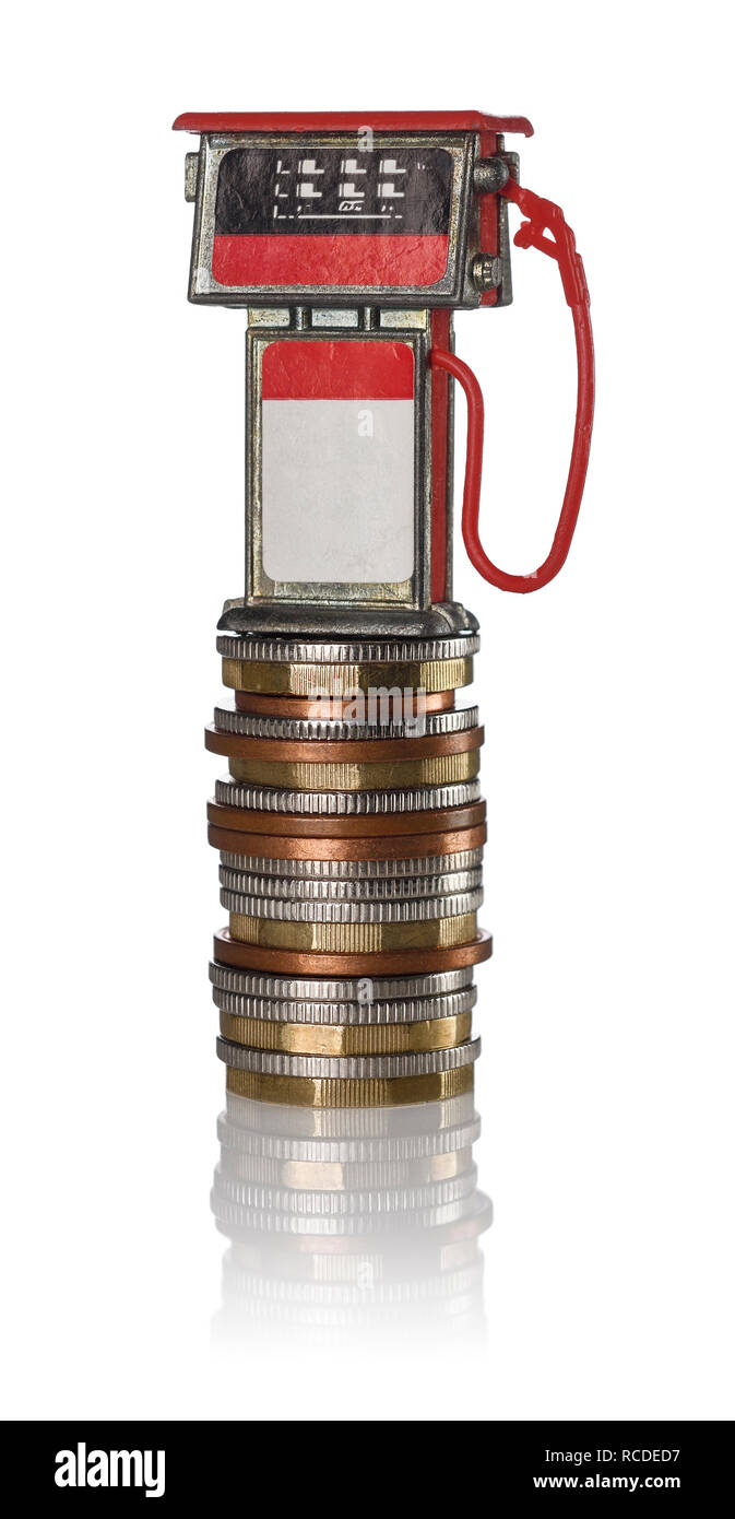 A red toy petrol pump sitting on a pile of coins Stock Photo