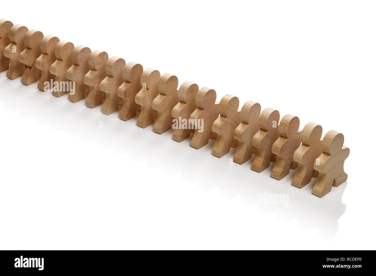 A straight line of small wooden people Stock Photo