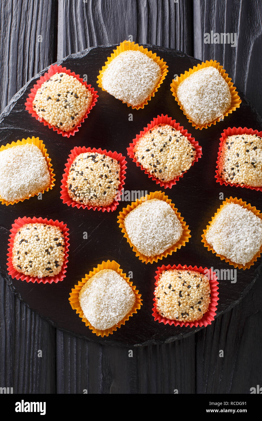 Japanese healthy rice dessert mochi daifuku with anko and sesame seeds closeup on the table