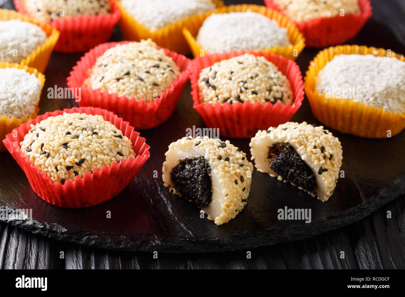 Japanese healthy rice dessert mochi daifuku with anko and sesame seeds closeup on the table