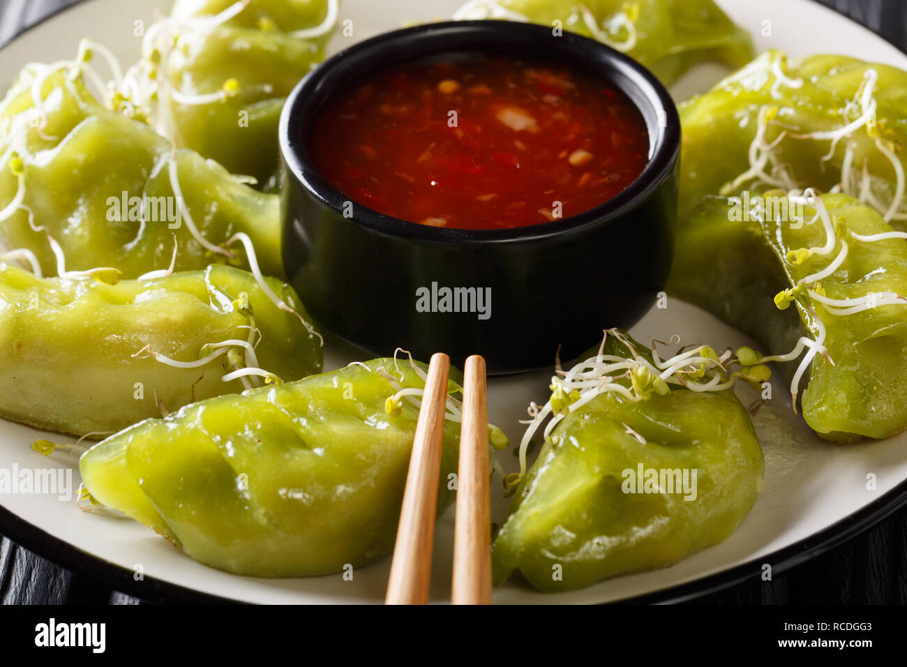 Japanese gyoza with matcha served with sauce and microgreen close-up on a plate. horizontal Stock Photo
