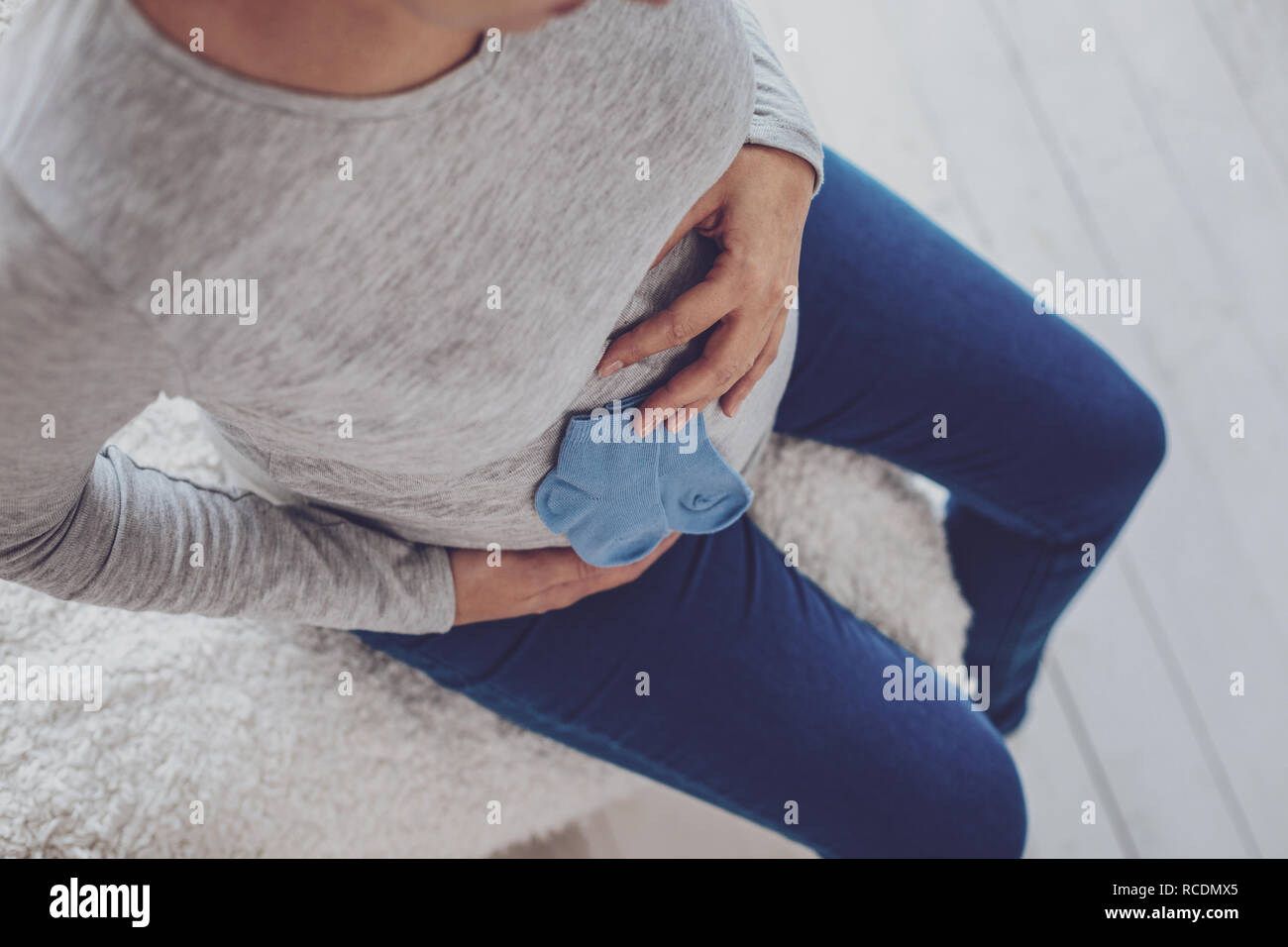 Top view of pregnant woman pressing blue socks to belly Stock Photo Alamy