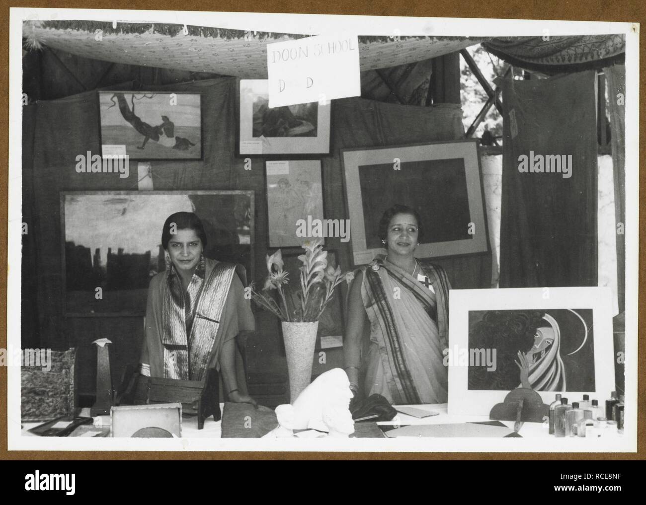 Doon School Stall [at the] Fancy Fair in Aid of the Indian Red Cross for War Purposes Fund, Savoy Hotel, Mussoorie. Two women at a stall selling artwork. Hallett Collection: '[Album] Presented to Lady Hallett by the District War Commitee, Dehra Dun, April 22, 1941'. 10-Jun-40. Photograph. Source: Photo 117/7(11). Author: UNKNOWN. Stock Photo