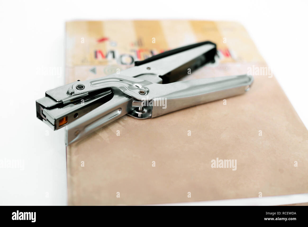 Stapler on the diary. Isolated on the white background. Stock Photo