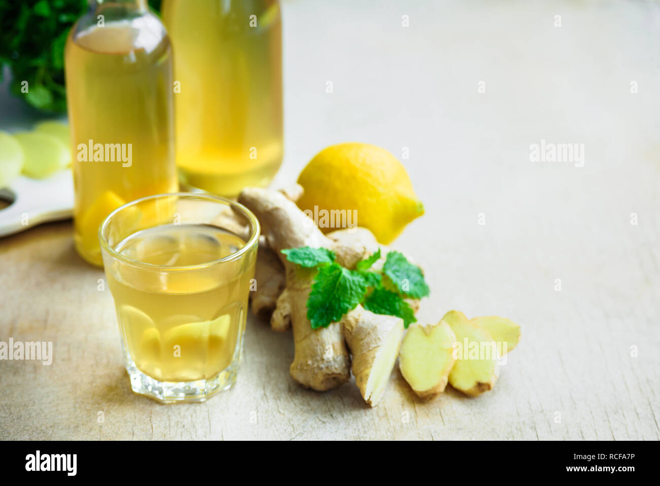 Bottle of detox ginger water on wooden background. Ingredients ginger, lemon, mint. Dieting concept. Stock Photo
