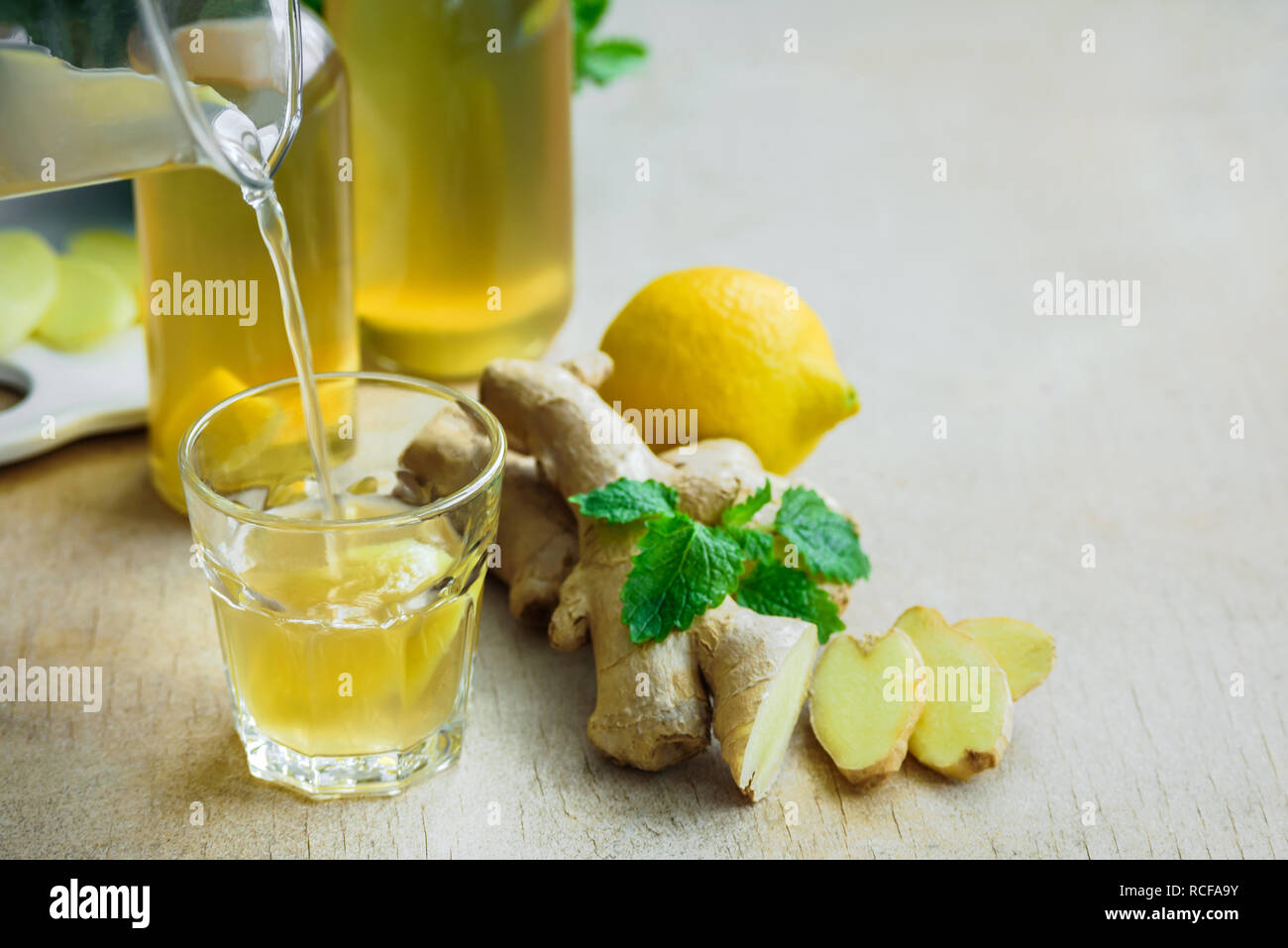 Bottle of detox ginger water on wooden background. Ingredients ginger, lemon, mint. Dieting concept. Stock Photo