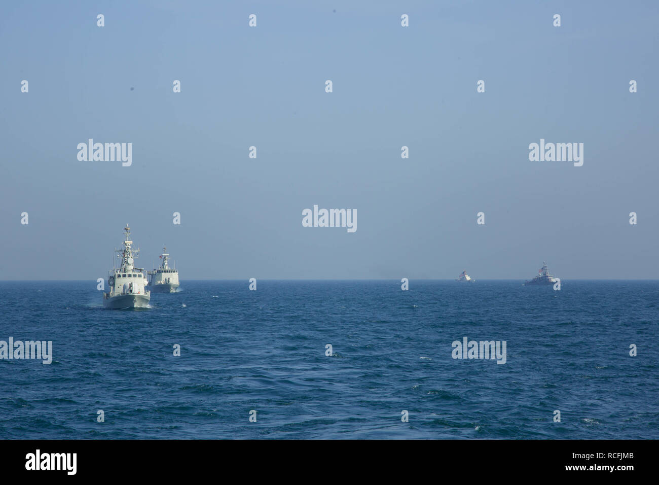 ARABIAN GULF (Jan. 9, 2019) U.S. Navy Cyclone-class coastal patrol ship USS Thunderbolt (PC 12), U.S. Coast Guard Island-class patrol cutter USCGC Wrangell WPD (1332), Royal Bahrain Naval Force Al-Manama-class FPB 62 guided-missile patrol combatant 50 and fast-attack missile craft Al Taweela 23 maneuver behind the Arleigh Burke-class guided-missile destroyer USS Decatur (DDG 73) during exercise Neon Union 19. Neon Union 19 is a bilateral air and surface maritime security operations exercise to strengthen critical warfighting capabilities and enhance interoperability and operational readiness b Stock Photo