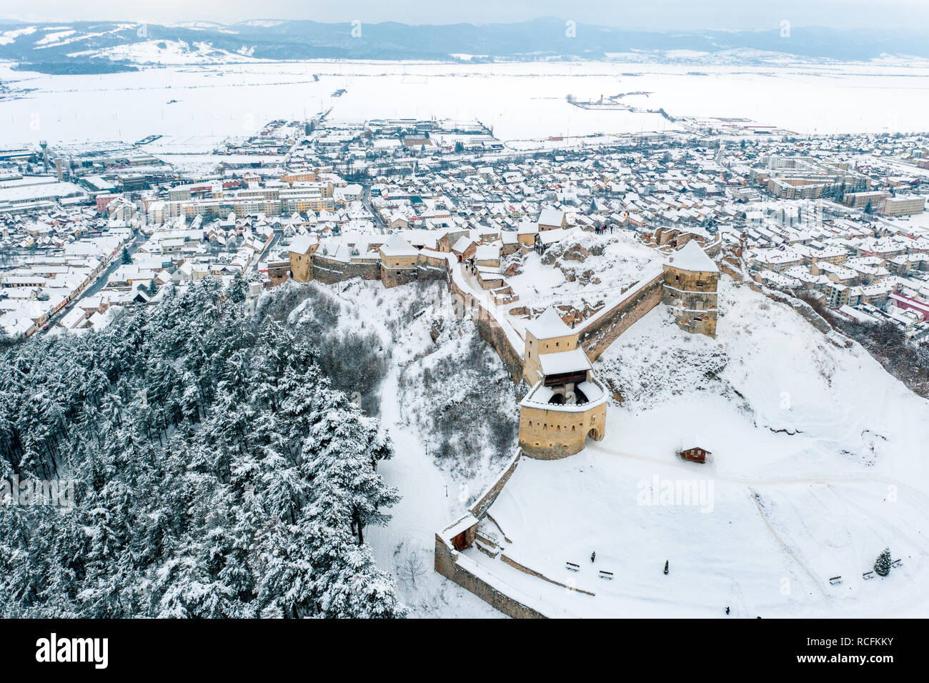 Winter at Rasnov Fortress with the Rasnov City visible in the Background Stock Photo
