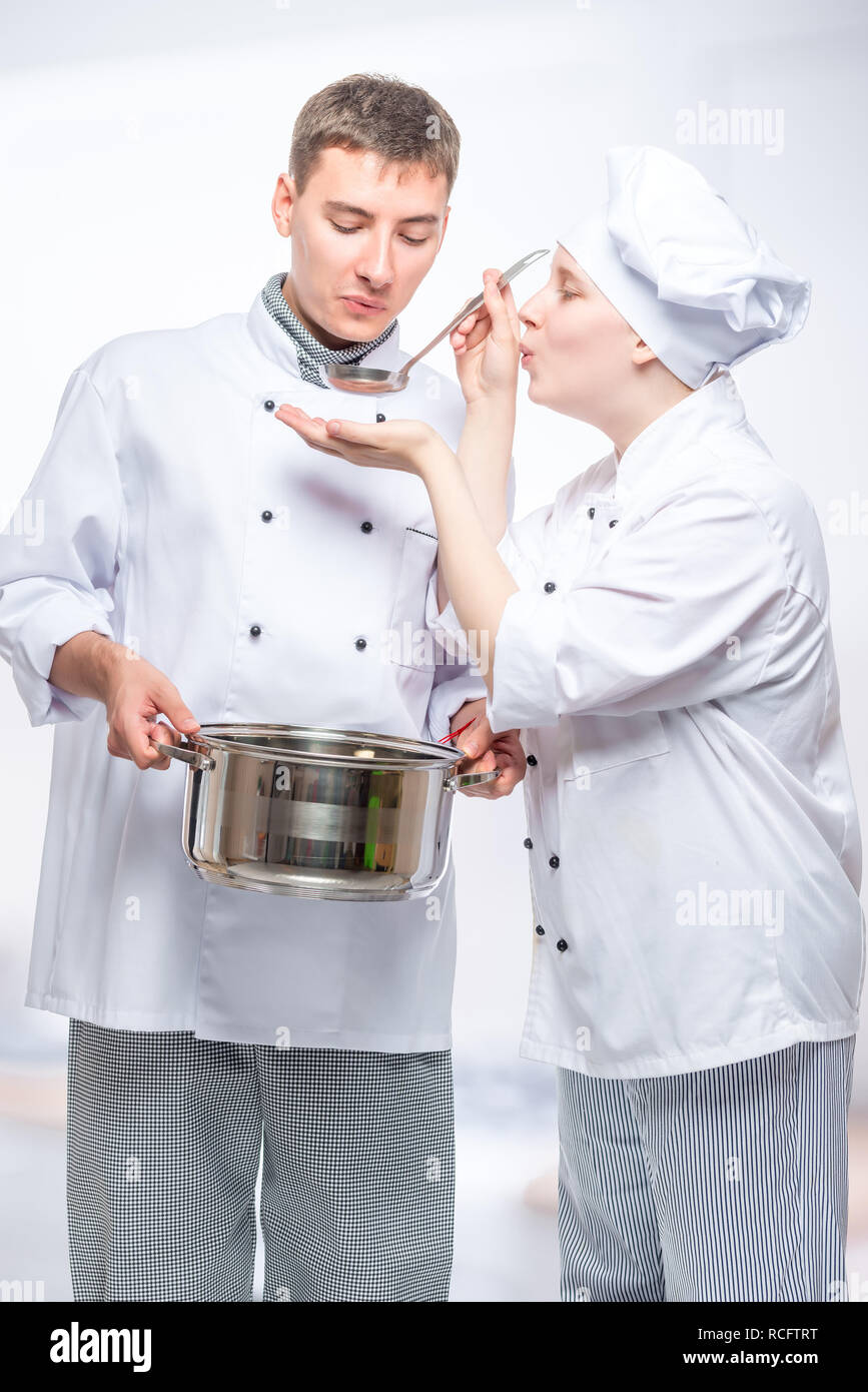 two cooks in suits try the cooked soup in the commercial kitchen Stock ...