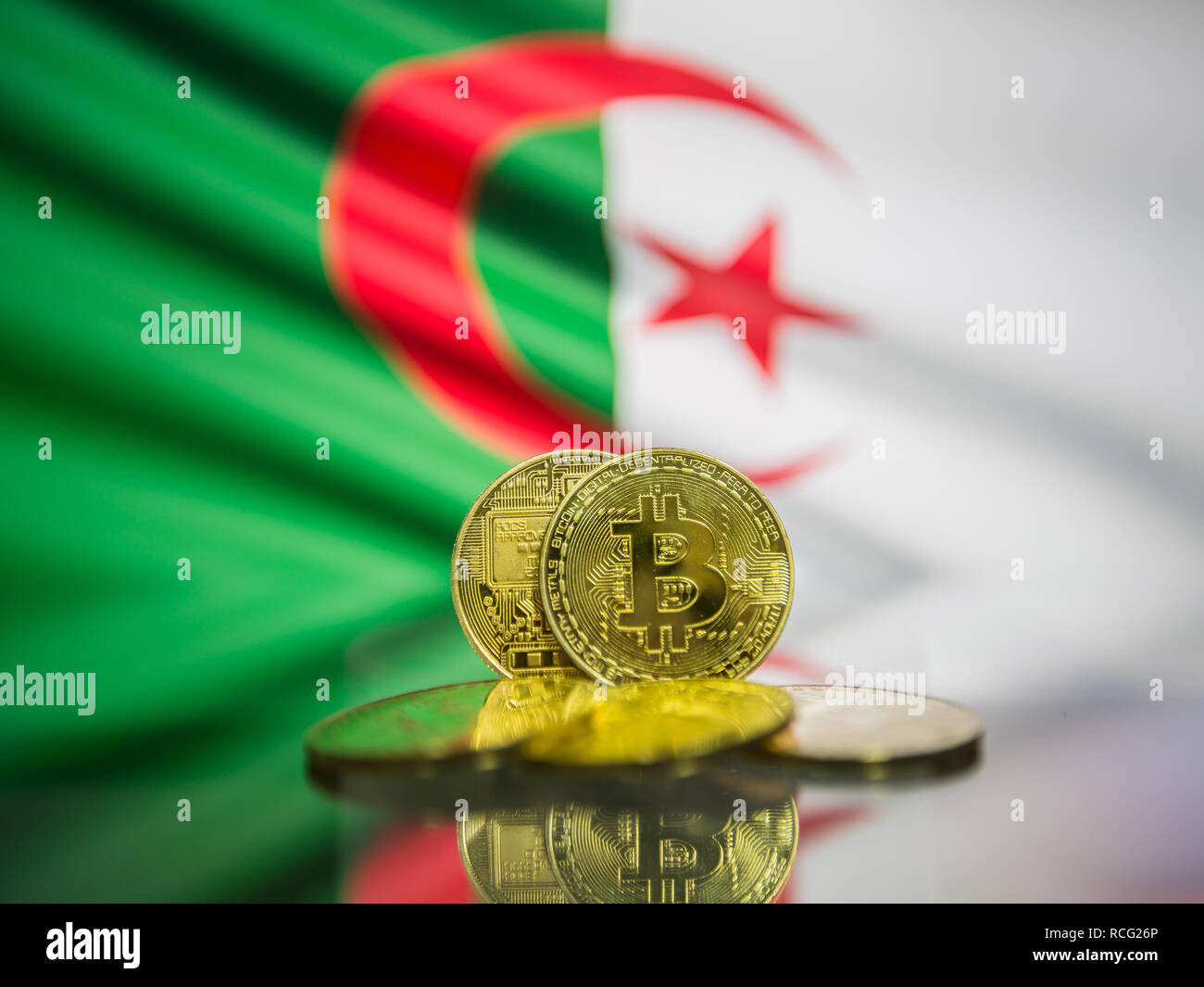 Bitcoin gold coin and defocused flag of Algeria background. Virtual cryptocurrency concept Stock