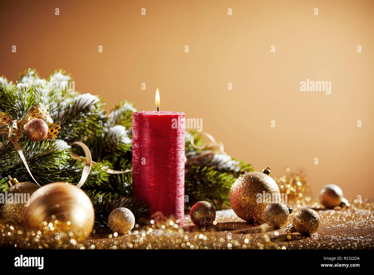 Decorative Christmas background with red candle, golden baubles and fir branches Stock Photo