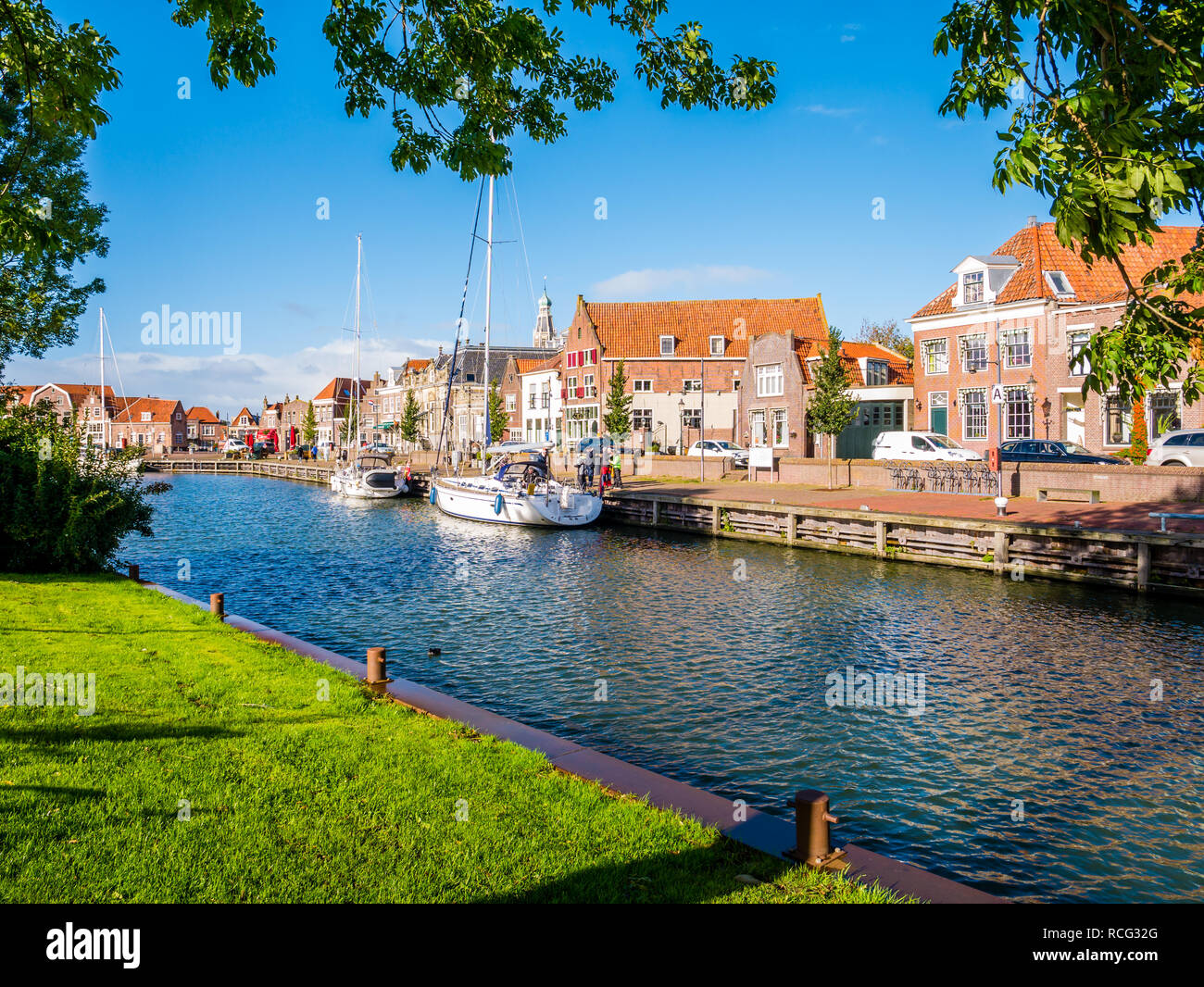 People and sailing boats in old harbour of historic town of Enkhuizen, Noord-Holland, Netherlands Stock Photo