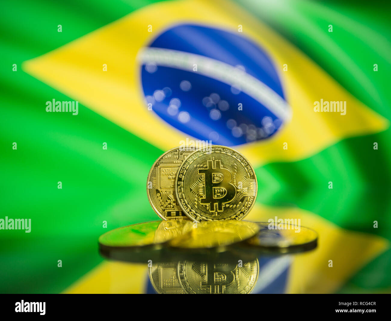 Bitcoin gold coin and defocused flag of Brazil background. Virtual