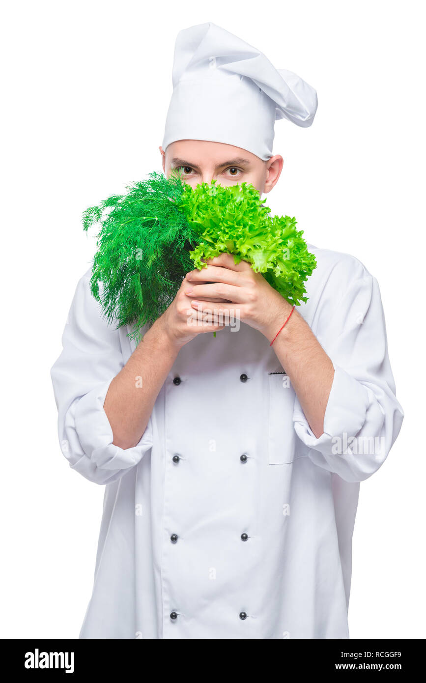 vertical portrait of an experienced chef with fresh greens on a white background Stock Photo