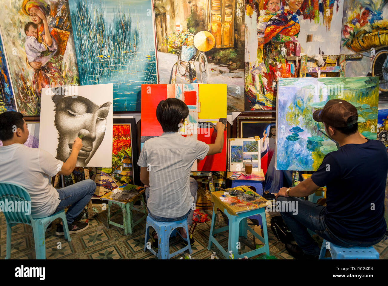 Artists in a commercial art gallery painting copies of well known European artworks, Hanoi, Vietnam Stock Photo