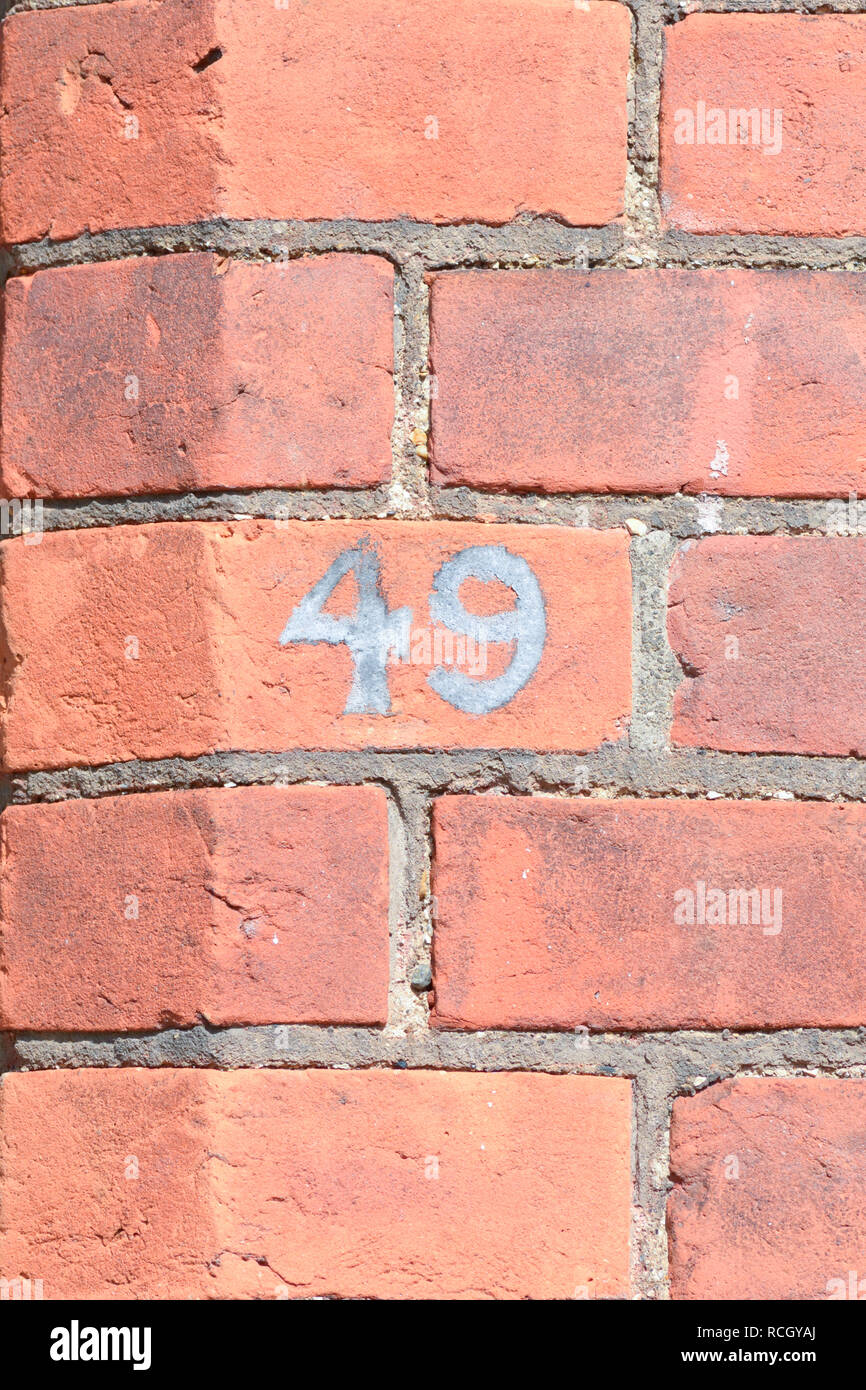 House number 49 sign painted on brick wall Stock Photo