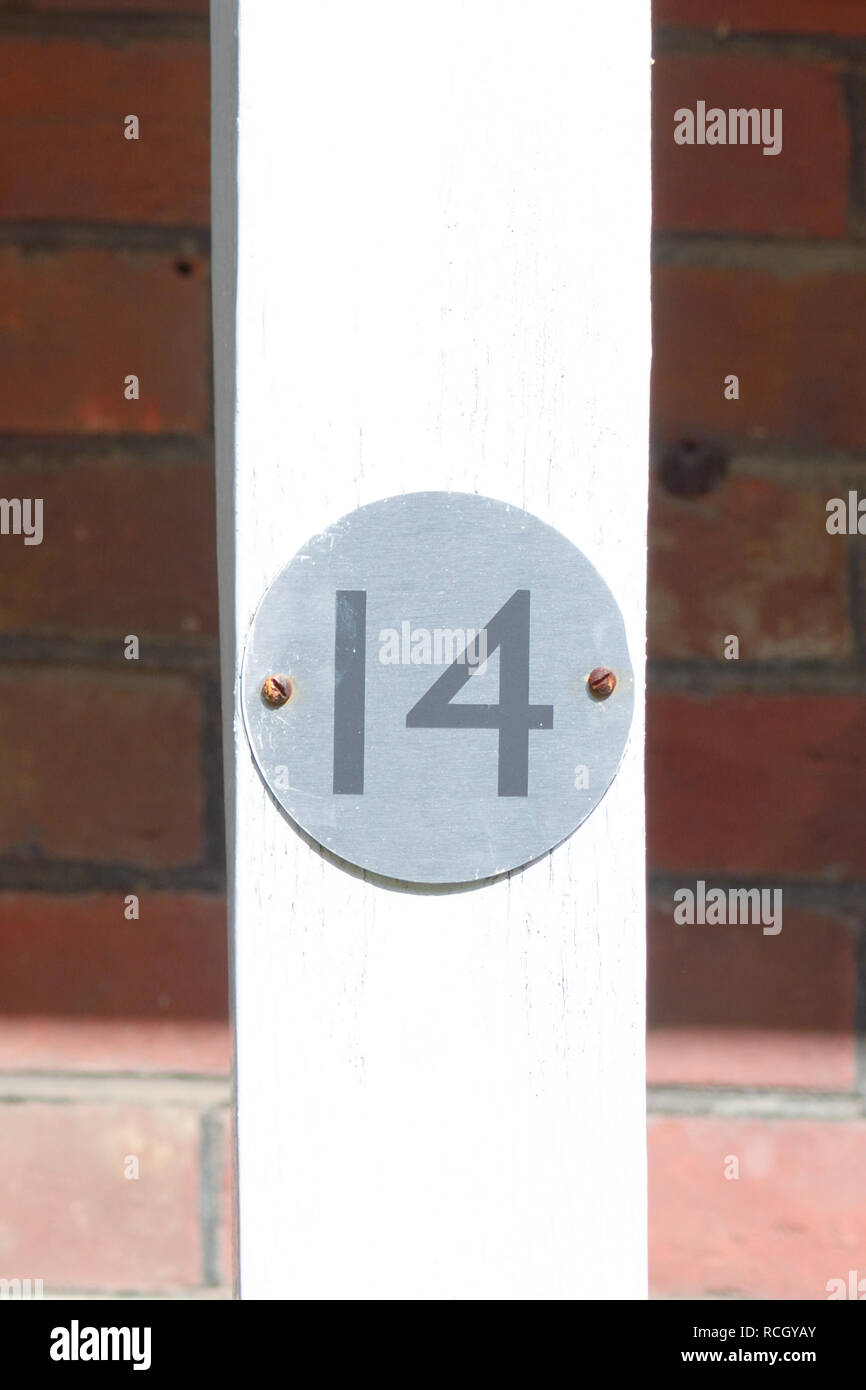House number 14 sign on wooden post Stock Photo