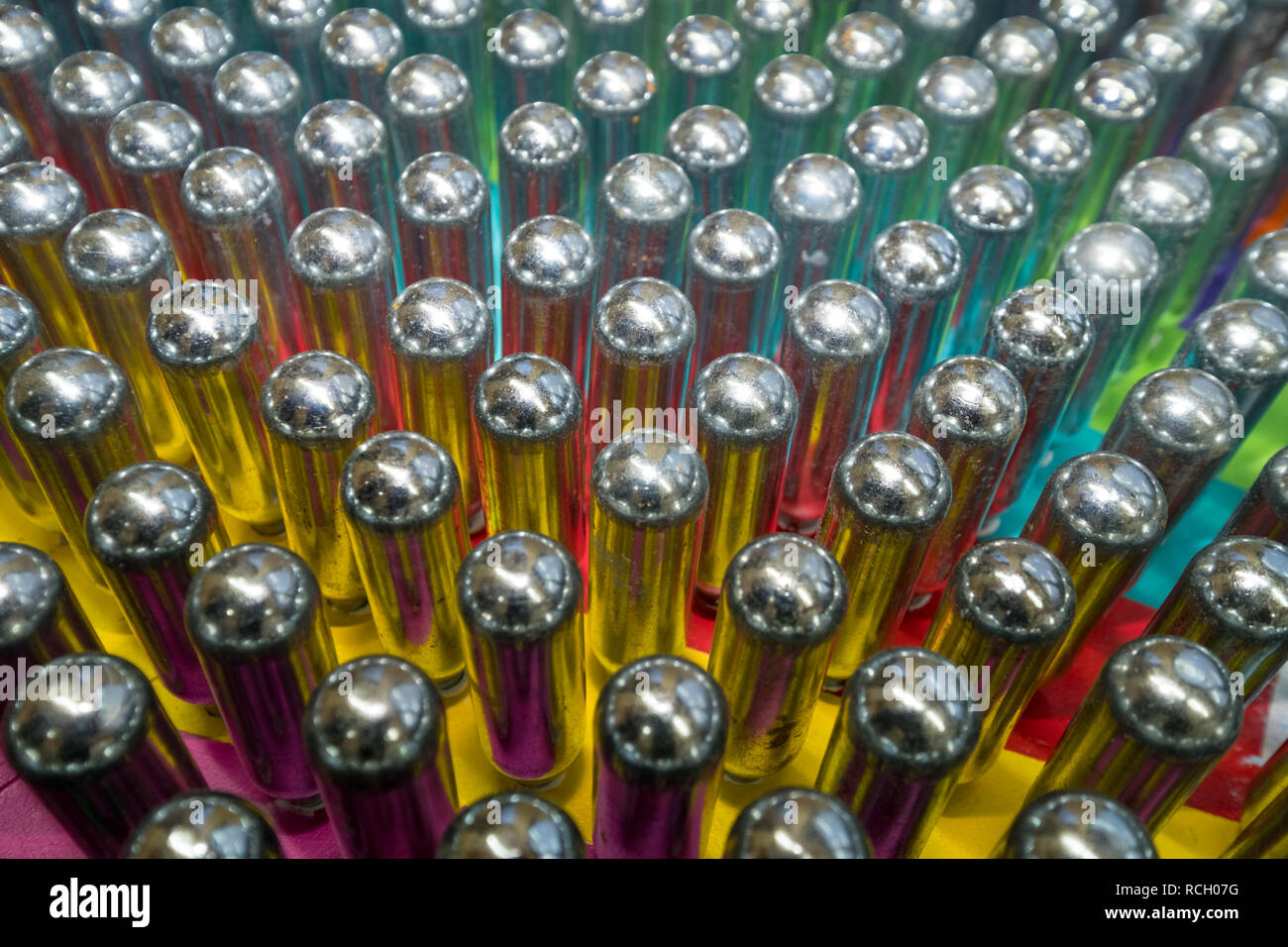 Laughing gas cannisters reflecting colourful background. These metal