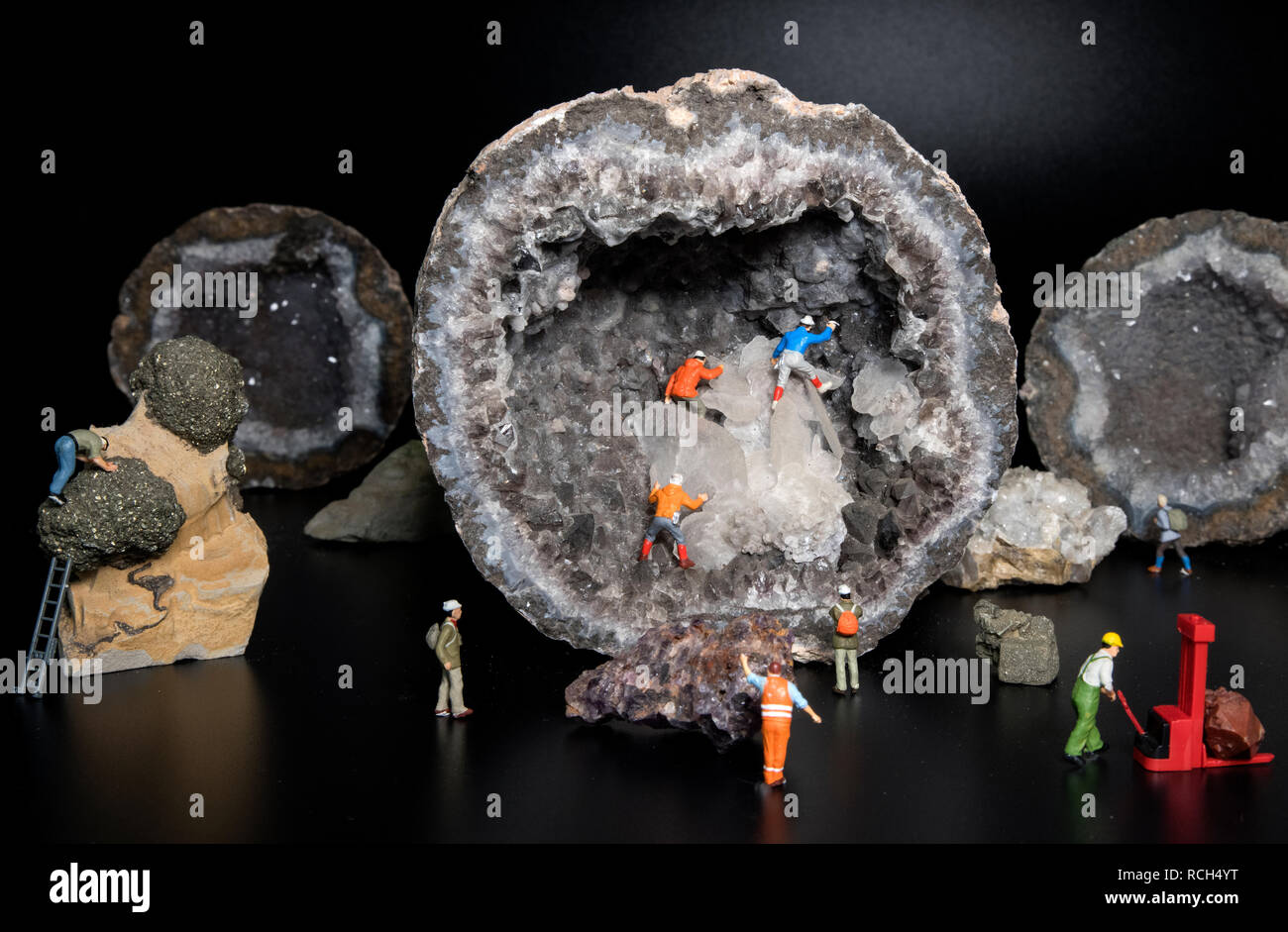 little puppets busy with cave exploring or mining with nice crystals and geode stone from millions years old Stock Photo