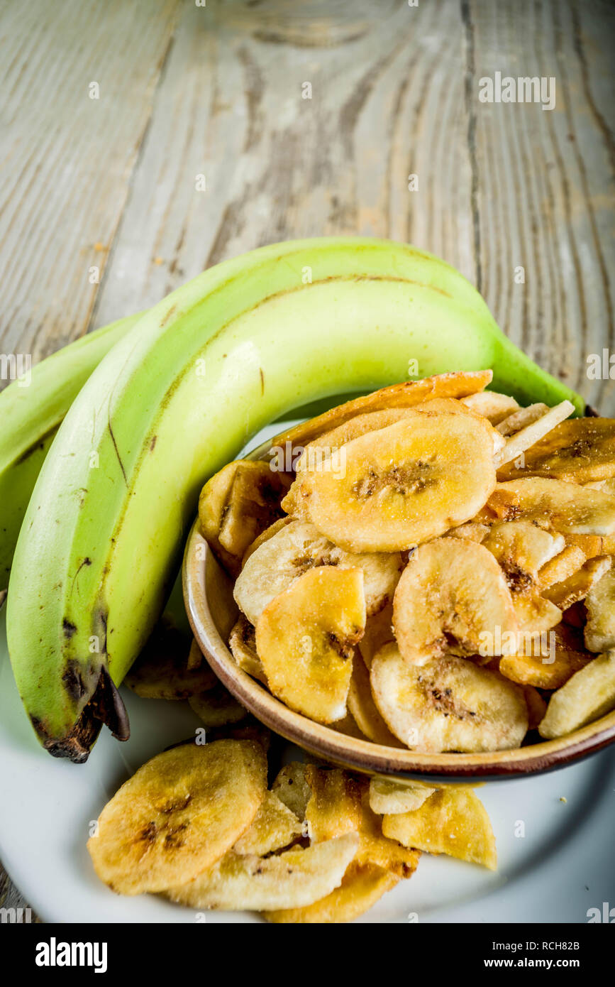 Dried bananas plantains with fresh bananas, wooden background copy