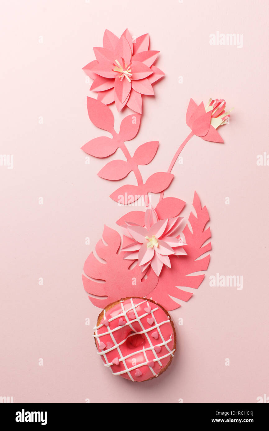 Handcraft plant corner from live coral paper with tropical leaf and donut.  A modern handmade paper application from colored paper on pink background. Stock Photo