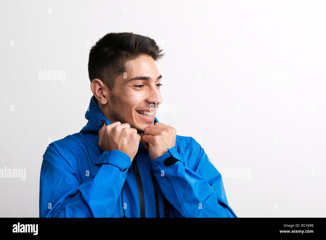 Portrait of a young hispanic man with blue anorak in a studio Stock ...