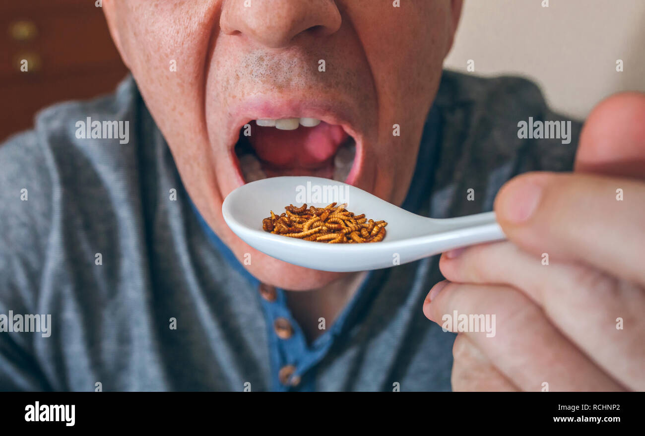 Man eating a spoonful of worms Stock Photo