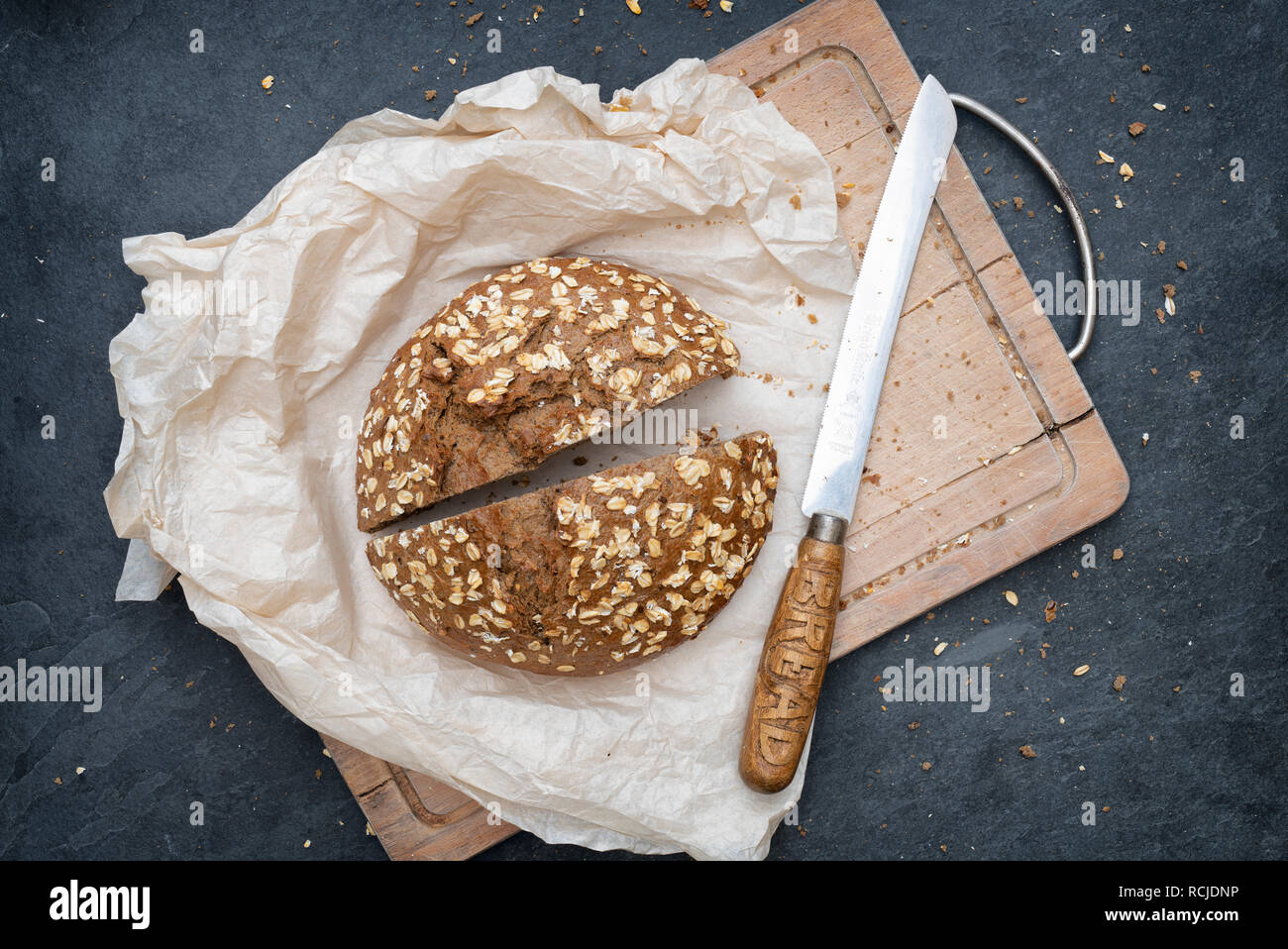 Light rye bread with a vintage bread knife on a bread board Stock Photo