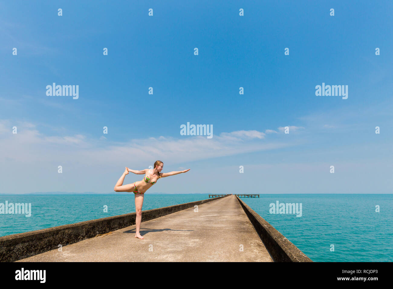 Nature yoga session on concrete Dai Mai pier - tropical koh Chang island in  Thailand. Warrior pose - Virabhadrasana Stock Photo - Alamy