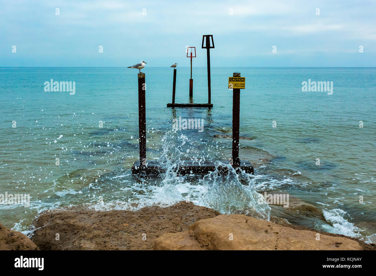 Landscape photograph taken from end of beach groyne at Sandbanks, Poole, of warning markers on submerged structure. Stock Photo