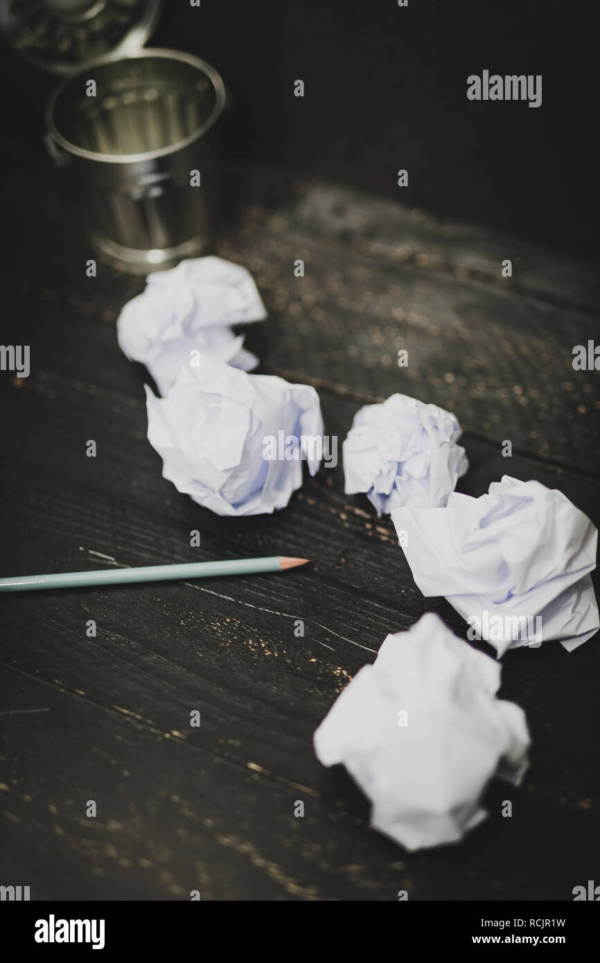 garbage bin on desk setting with pencil and scrunched paper balls ...
