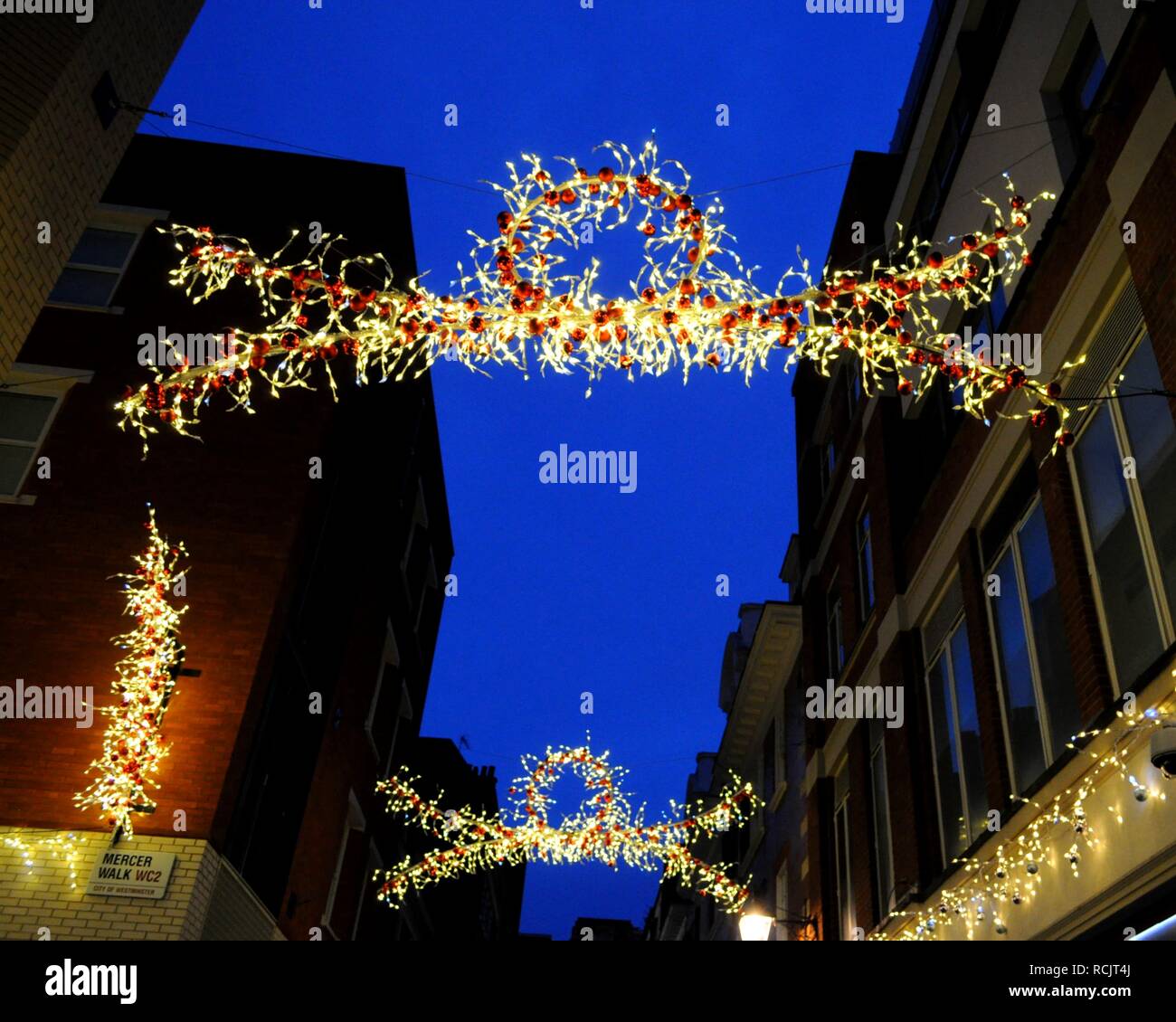 Christmas light display leading over Mercer Street, London, UK. Stock Photo