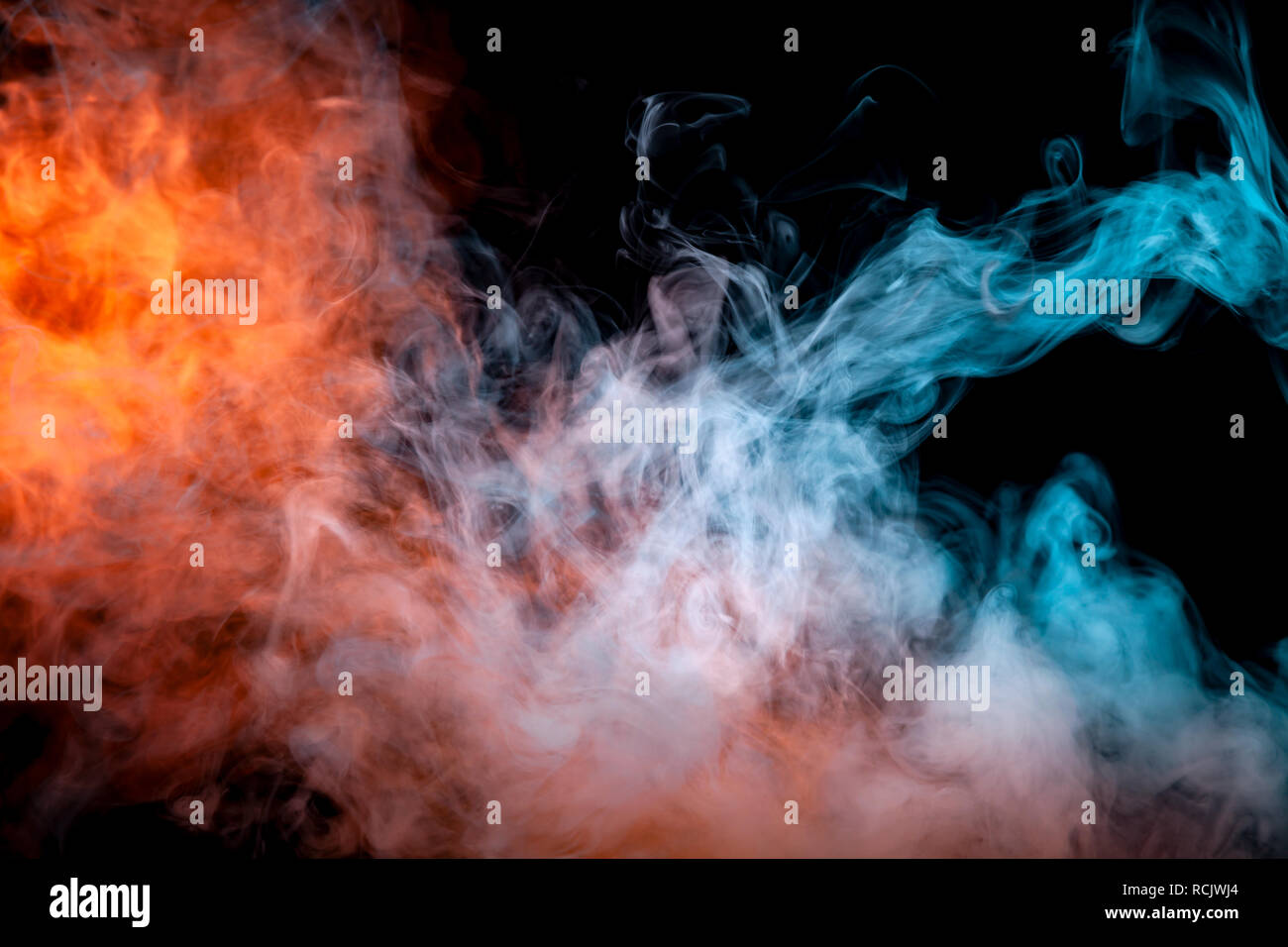 Thick smoke exhaled from a vape, highlighted by a blue-violet orange color like a flame an explosion against a black background, dynamically in a risi Stock Photo